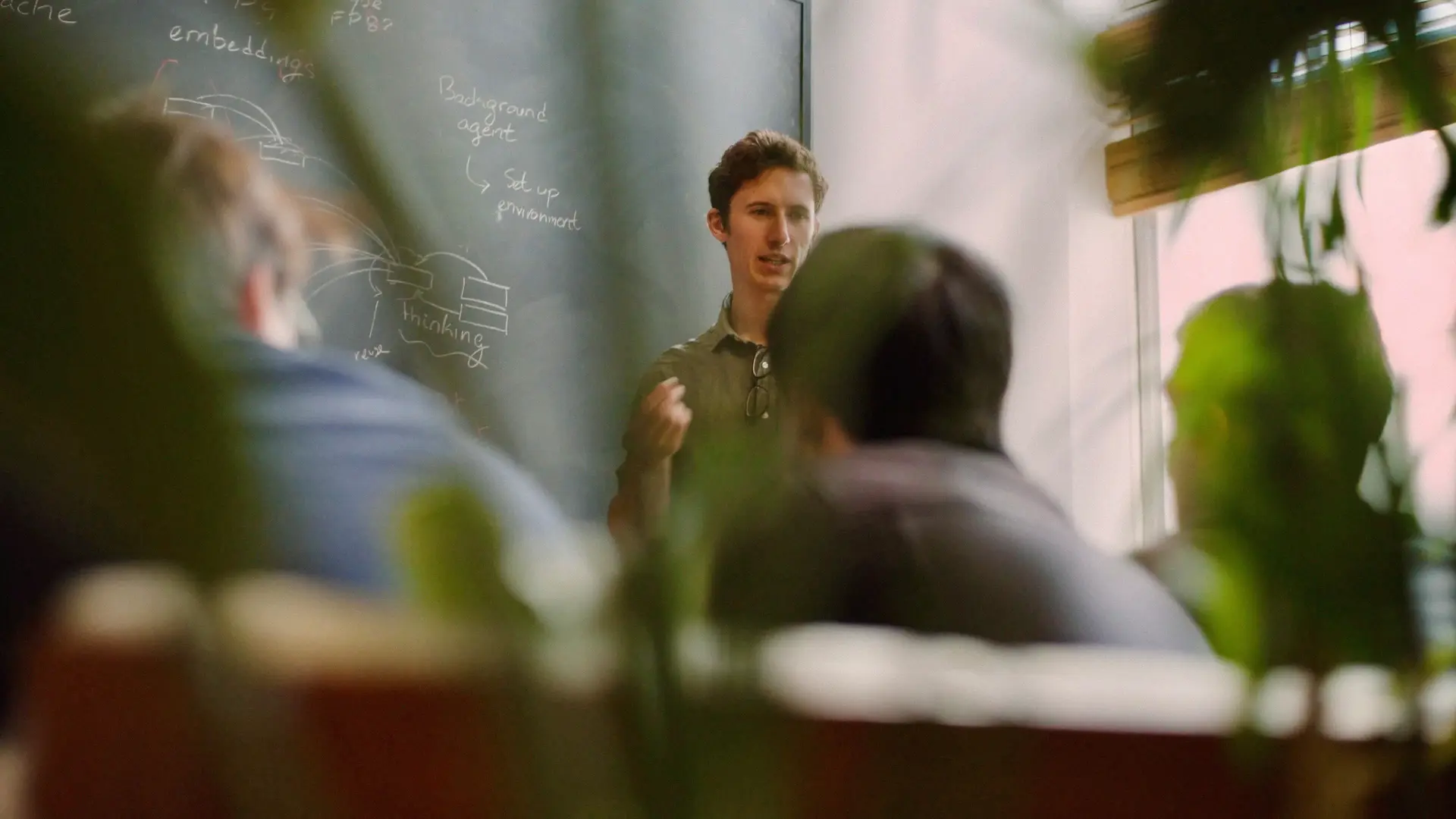Cursor engineers having a team whiteboard discussion about AI agent architecture.